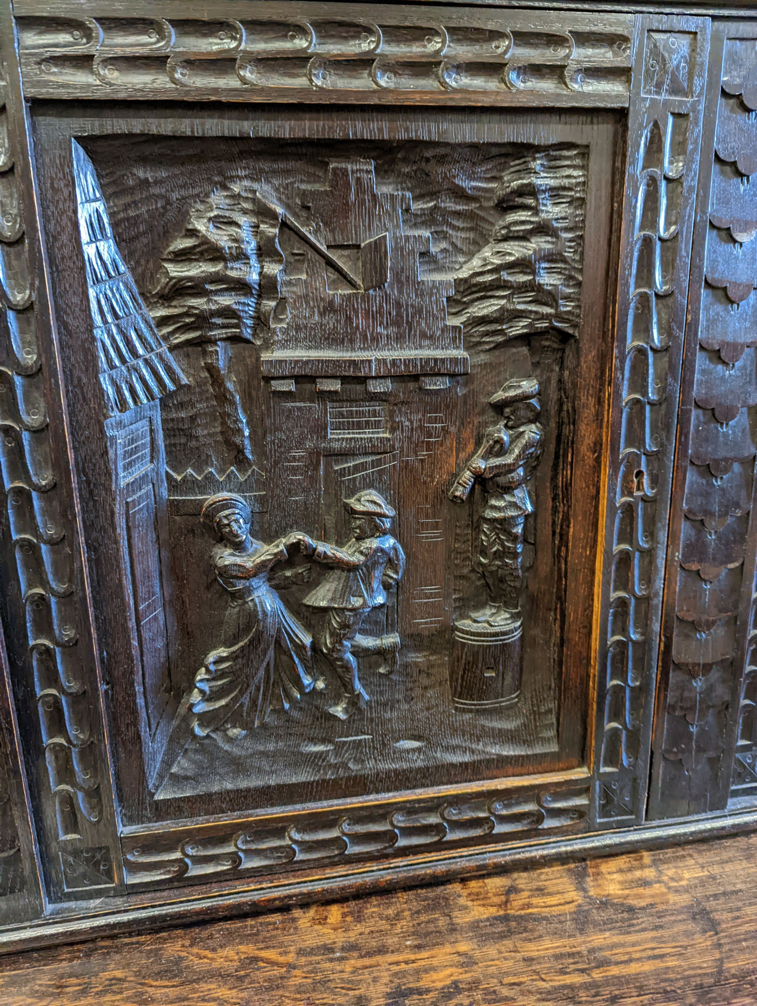 An early 20th century carved oak court cupboard in the Flemish style, length 200cm, depth 58cm, height 212cm